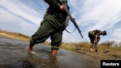 克钦独立军士兵淌过一条溪流,前往拉咱前线。(2013年2月4日资料照)