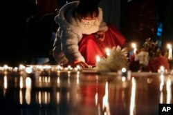 资料照:一名香港小女孩在香港中文大学曾经矗立自由女神的地点点燃了一枚蜡烛纪念六四死难者。(2021年12月24日)