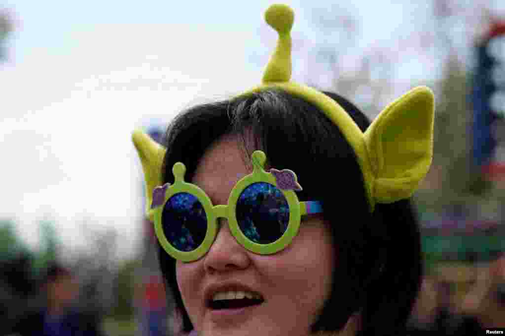 2018年4月26日在上海举行的迪士尼-皮克斯公司的玩具总动员园区中,一位女士戴着电影角色玩具装饰。这个园区是上海迪士尼乐园的第七个主题园区。 在美中贸易关系紧张之际,华特迪士尼公司强调其与中国的深层关系。