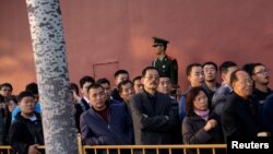 中共十九大举行之际,人们排队等待进入北京天安门广场,有武警站岗(2017年10月22日)