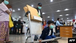 Một đứa trẻ mang khẩu trang tại phi trường quốc tế Yangon ngày 31/1/2020. HHK Myanmar đình chỉ các chuyến bay sang TQ sau khi WHO tuyên bố tình trạng khẩn cấp y tế toàn cầu do virus nCoV. (Photo by Ye Aung THU / AFP)