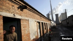 2015年12月10日一民工走出北京一家燃煤电厂附近的住所