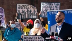 Murad Awawdeh, right, with the New York Immigration Coalition, speaks at a rally asking President-elect Joe Biden to prioritize immigration reform, Nov. 9, 2020, in New York.