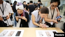 2018年9月21日,上海的苹果公司办公室对媒体展示新产品,人们体验新的Apple iPhone XS和iPhone XS Max。