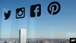 资料照:一扇玻璃窗上显示的推特、脸书等社交媒体的标识。