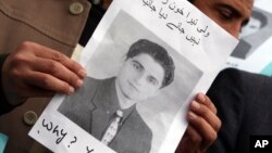 Pakistani journalists hold a poster of Karachi-based slain journalist Wali Khan Babar during a protest in Peshawar, Pakistan, Jan. 14, 2011.