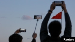 资料照:北京天安门上观看早上升期仪式的人们。(2019年5月19日)