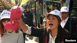 资料照片-失独父母在北京中国国家卫生和计划生育委员会外的集会上高呼口号。(2016年4月18日)