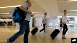 Dror Heitner, left, walks with his wife Rinat Heitner, right, and their 16-year-old son Ori Heitner toward a security checkpoint at Newark Liberty International Airport, July 22, 2014, in Newark, N.J.