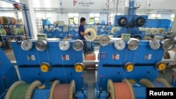 资料照片:中国浙江省湖州市的一个通讯设备厂光纤生产线上的工人在工作。(2020年5月15日)