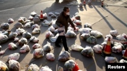 中国陕西西安新冠防疫封城后一名工作人员为居家隔离的小区居民准备递送食品。(2021年12月23日)