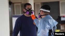 在美国德克萨斯州圣安东尼奥的东南护理康复中心疗养院,身穿防护服的急救人员正在为自己消毒,那里的许多居民和员工都感染了冠状病毒病。(2020年4月4日)