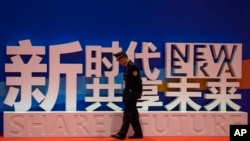 一名警卫在上海中国国际进口博览会的口号前走过。(2018年11月5日)