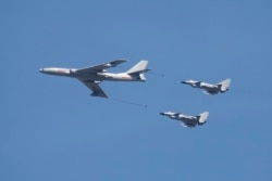 资料照:中国空军一架轰-6和两家歼-10战斗机在北京参加庆祝抗战胜利70周年纪念活动。(2015年9月3日)