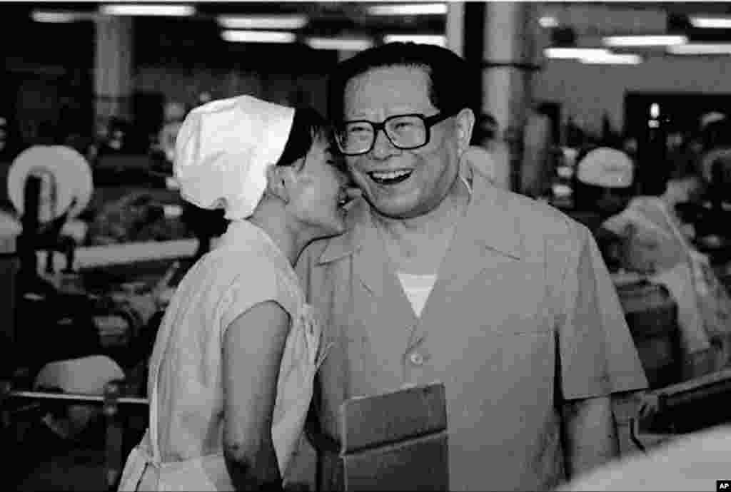 1995年6月19日,中国主席江泽民访问哈尔滨一个纺织厂,和纺织女工交谈。由于车间噪音大,所以只能凑近了说话。