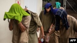 因在津巴布韦住所查获犀牛角被捕的七名中国公民1月3日首次在维多利亚瀑布地方法院出庭。离开法庭时,他们中有人为避开摄像机用毛巾遮盖脸部