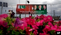 巴基斯坦路边立着欢迎中国国家主席习近平访问的广告牌。上面依次为巴基斯坦总统侯赛因(左)中国国家主席习近平(中)和巴基斯坦总理谢里夫(2015年4月19日)