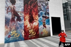 2025年2月11日,一个男孩跑过电影“哪吒2”的海报。
