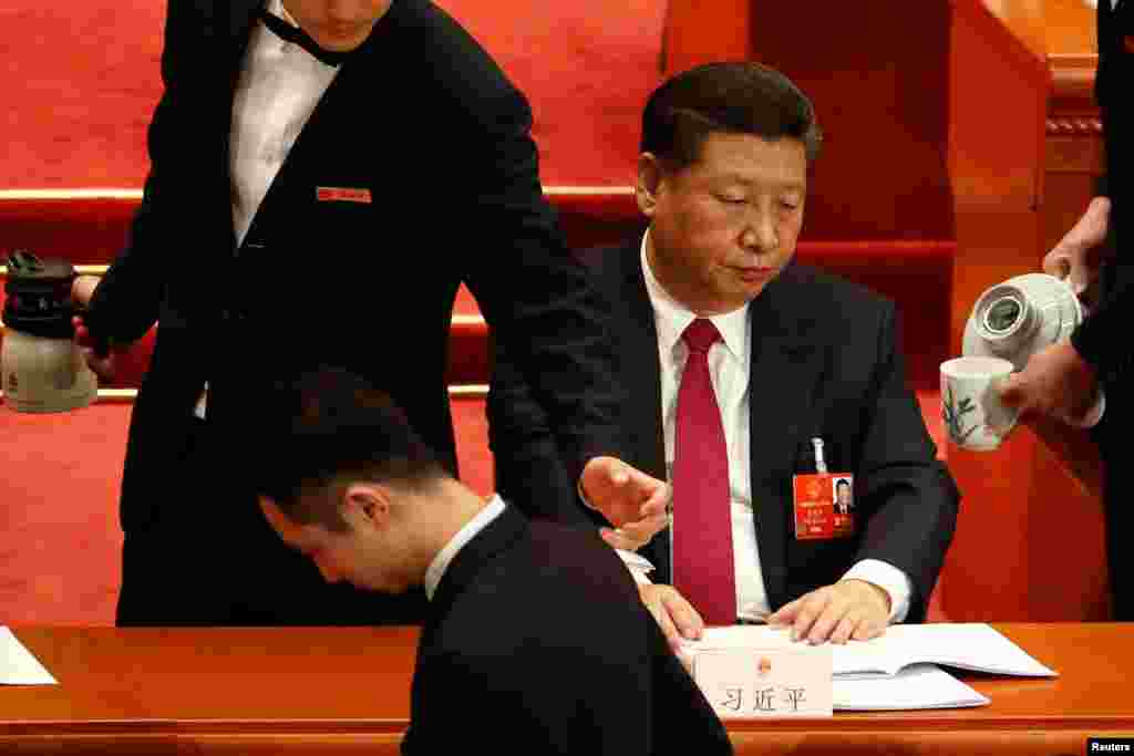 2018年3月9日,在北京人民大会堂举行的全国人民代表大会第二次全体会议上,服务员给国家主席习近平倒茶。从一些照片来看,给习近平等高官端茶倒水的是这些男服务员,给人大主席团后排的人倒水的是女服务员。