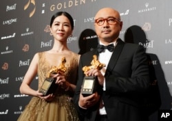 在台湾台北举行的第55届金马奖典礼上的最佳男主角奖得主徐峥(《我不是药神》)和最佳女主角奖得主谢盈萱(《谁先爱上他的》)(2018年11月17日)。