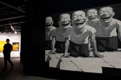 一名男子走过香港苏富比拍卖的中国艺术家岳敏君的绘画“狮子”的广告。(2020年10月3日)