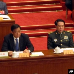 中共中央政治局委员,重庆市委书记薄熙来(前左一)在人大主席台就座