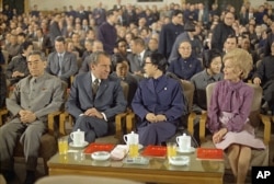 1972年2月28日,上海,中国总理周恩来和毛泽东夫人江青陪美国总统尼克松和夫人观看文艺演出。坐在江青后面的戴眼镜者是郭沫若。