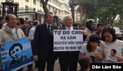 Ông Felix Schwarz, phụ trách Chính trị và Nhân quyền của Đại sứ quán Đức và dân biểu Đức Martin Patzelt cầm biểu ngữ kêu gọi trả tự do cho blogger Anh Ba Sàm và bà Nguyễn Thị Minh Thúy bên ngoài tòa án.