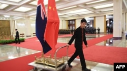 资料照:北京人大会堂一名工作人员在运送中国和新西兰国旗。(2019年4月1日)