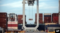 在美国乔治亚州萨凡内港一架起重机正把一个集装箱装进一艘集装箱船上(2018年7月5日)