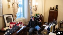 资料照片:理查德·巴内特在冲击国会大厦事件期间在时任议长南希·佩洛西的办公室内把脚放在桌上。(2021年1月6日)