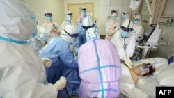 2020年3月1日,武汉红十字会医院的医护人员正在治疗一名感染新冠病毒的危重病人。