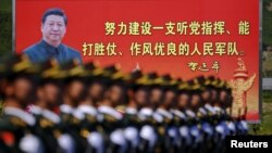 资料照:解放军士兵列队在中国领导人习近平画像前走过。(2015年8月22日)
