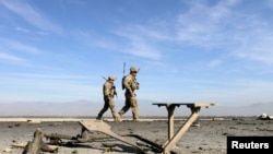 FILE - U.S. troops inspect at the site of a suicide attack on the outskirts of Jalalabad, Nov. 13, 2014.