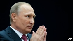 A man and a woman hold hands aloft in Hyde Park during a "Black Lives Matter" protest in London, following the death of George Floyd who died in police custody in Minneapolis, USA.