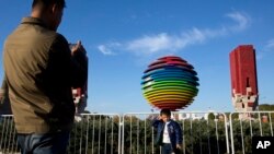 2014年11月6日,一名男孩在APEC北京峰会标志附近拍照。为了能让与会者呼吸到更清新的空气,中国政府采取了一系列强制措施。