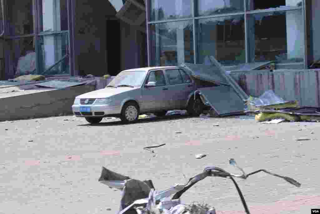 天津爆炸事故现场,核心爆炸区周围多座居民楼窗户被震碎,高速公路桥梁受损,多辆大货车被炸翻,小汽车起火或被砸,多名当地居民仍逗留在事故现场。(美国之音记者东方拍摄)