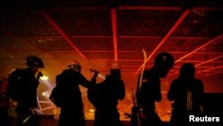 香港理工大学的抗议者被大火映出的身影。(2019年11月18日)