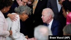 美国总统拜登在白宫东厅正式签署法律将六月节设为联邦假日后,与奥帕尔·李握手交谈。(2021年6月17日)