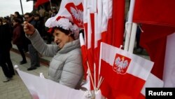 华沙街头一名小贩出售带有国徽的波兰国旗庆祝该国的宪法日。(2017年5月3日)