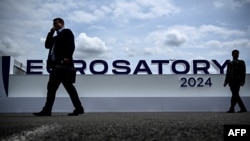 资料照片:2024年6月17日,在巴黎北郊维勒班特,参观者走过欧洲国际防务展(Eurosatory)的标志前。