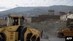 在这张拍摄于2023年11月21日的照片中,阿富汗建筑工人在喀布尔Sara-e-Shamali地区的一条道路上工作。