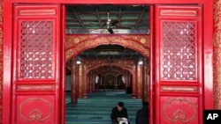 2024年3月12日,星期二,在中国北京牛街清真寺,一名穆斯林在斋月第一天等待开斋时阅读《古兰经》。(美联社)