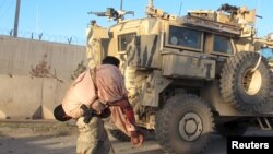 အာဖဂန်လုံခြုံရေးတပ်ဖွဲ့ဝင်တဦး ဒဏ်ရာရသူတဦးကို သယ်ဆောင်လာစဉ်။ (နိုဝင်ဘာ ၁၅၊ ၂၀၁၅)