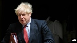 资料照片:英国首相约翰逊离开唐宁街10号,前往参加每周在议会举行的首相问答会。(2020年7月15日)