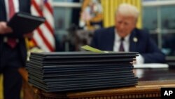 Tanpa buang waktu, usai pelantikan, Presiden AS Donald Trump langsung menandatangani setumpuk instruksi presiden untuk berbagai isu penting, di Gedung Putih hari Senin, 20 Januari 2025.