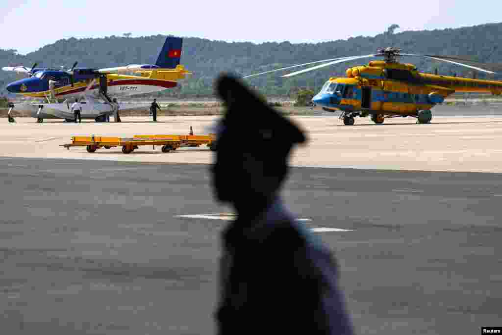 3月10日，在越南富国岛的机场，一名军官守卫在即将出发搜寻马航失联班机的越南飞机旁