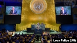 秘书长古特雷斯(讲台上和屏幕上)2025年9月22日在联合国成立八十周年纪念大会上发表讲话。