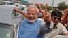 Hindu nationalist Narendra Modi, the prime ministerial candidate for India's Bharatiya Janata Party (BJP), gestures towards his supporters from his car during a road show upon his arrival at the airport in New Delhi, May 17, 2014.