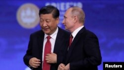 На фото: Червень 2019, Володимир Путін та Сі Цзіньпін спілкуються на Петербурзькому міжнародному економічному форумі